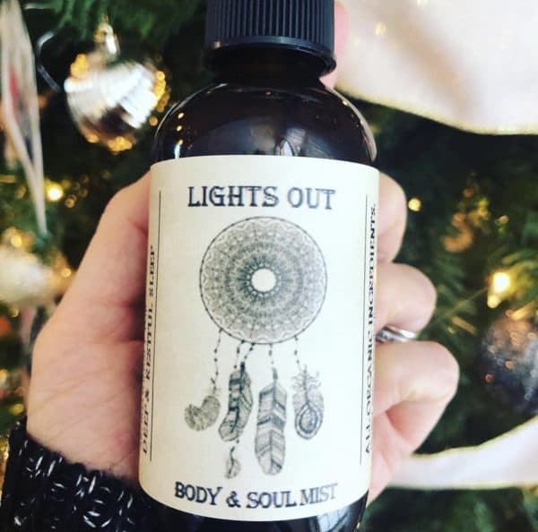 bottle of lights out in front of xmas tree