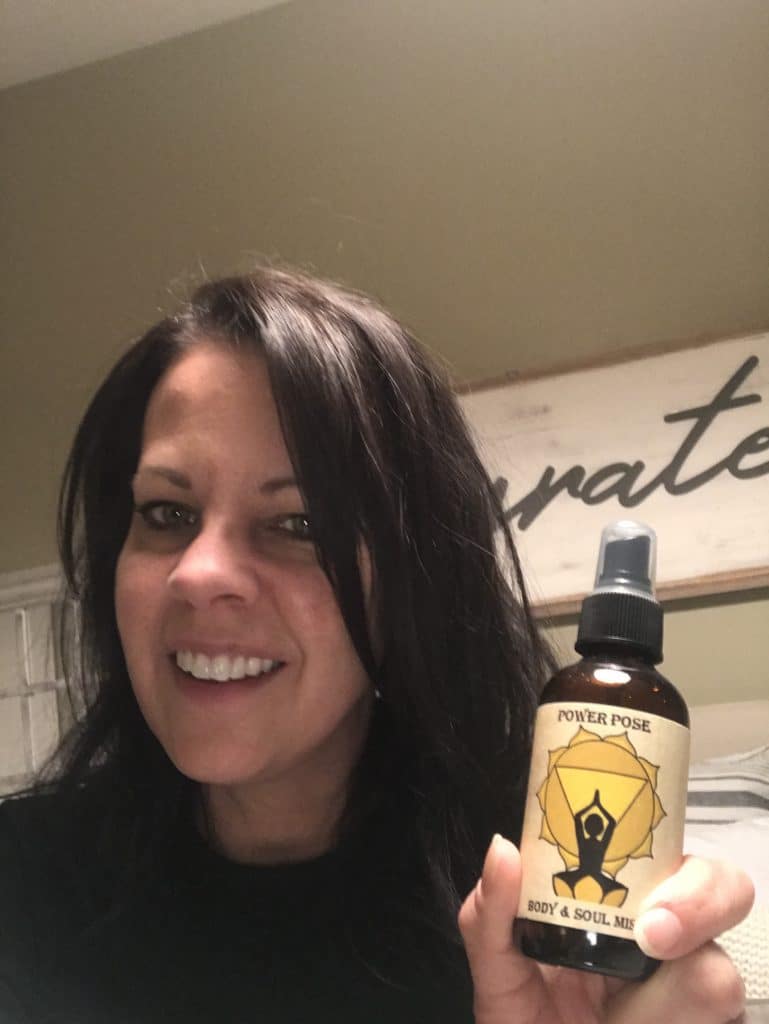 jennifer smiling and holding a bottle of Power Pose mist