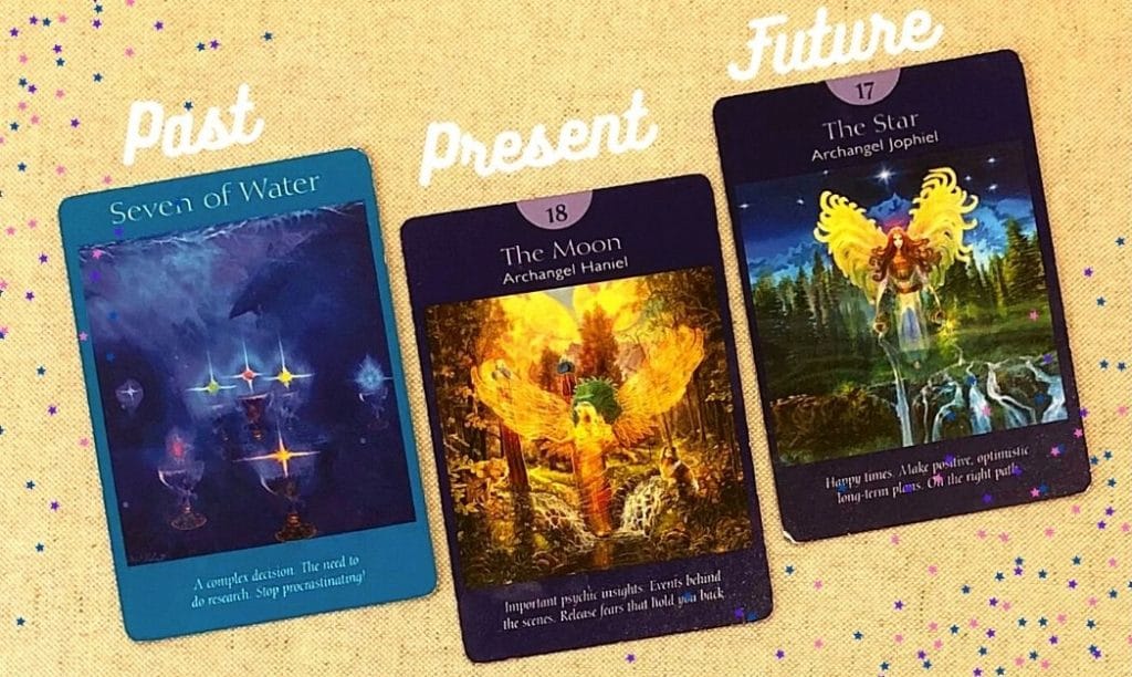3 tarot cards on a while table labelled past, present, and future