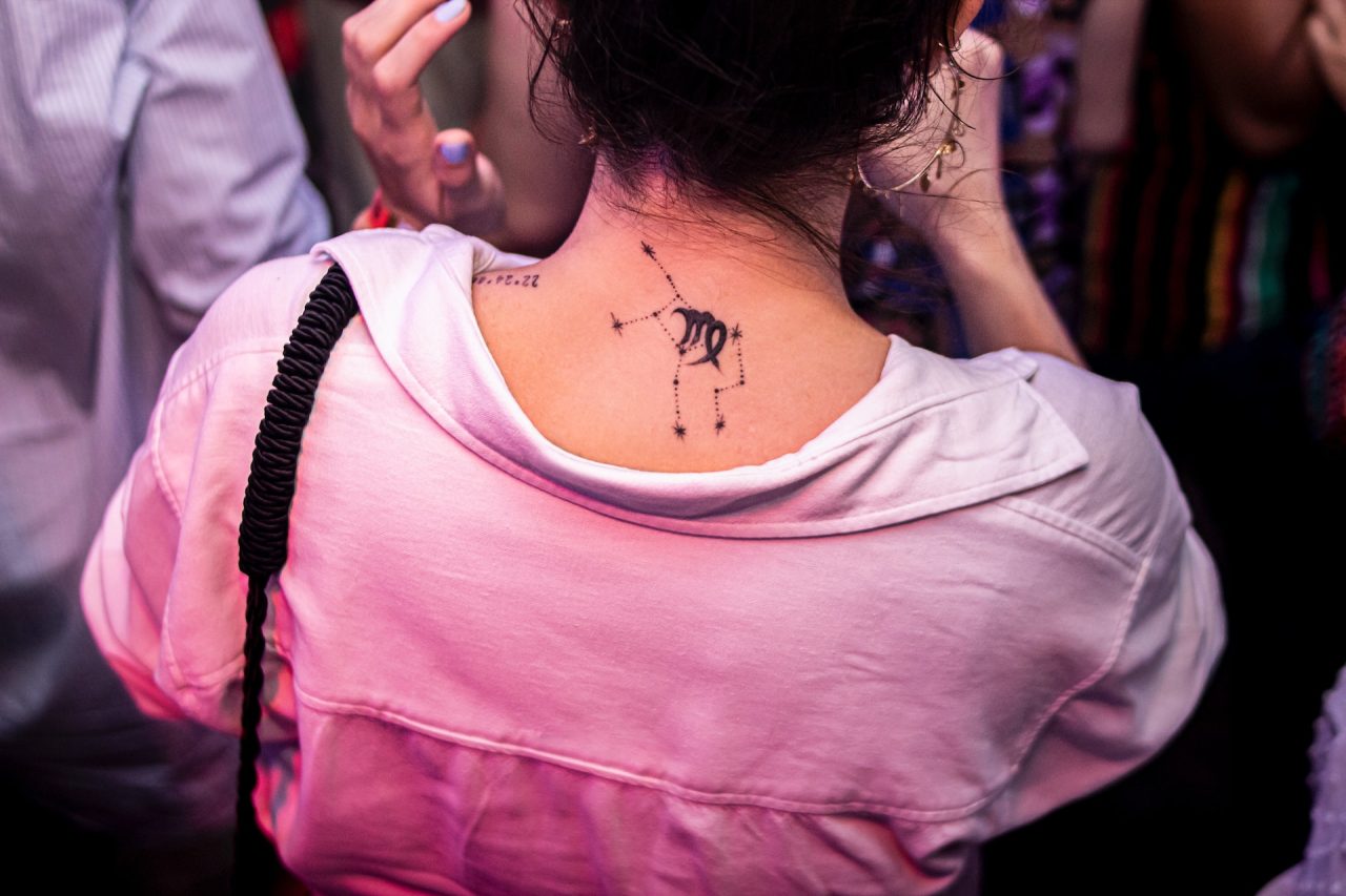 woman with zodiac tattoo on back of her neck