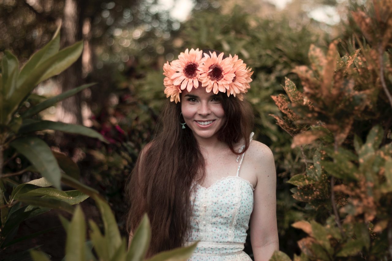 smiling woman wearing floral crown outdoors