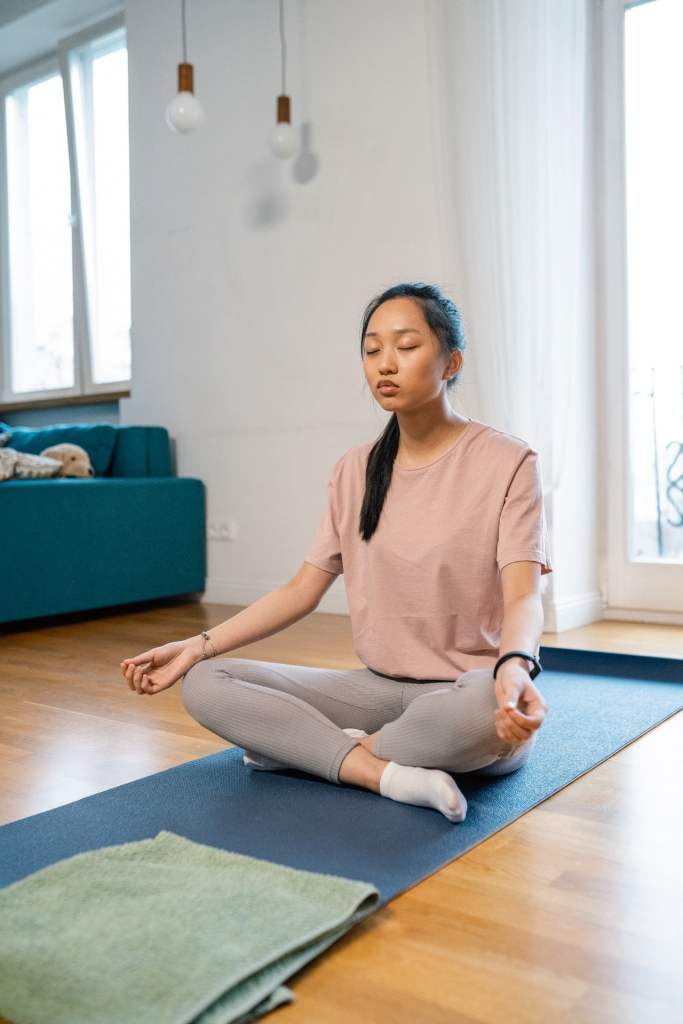 woman on yoga mat sitting cross legged