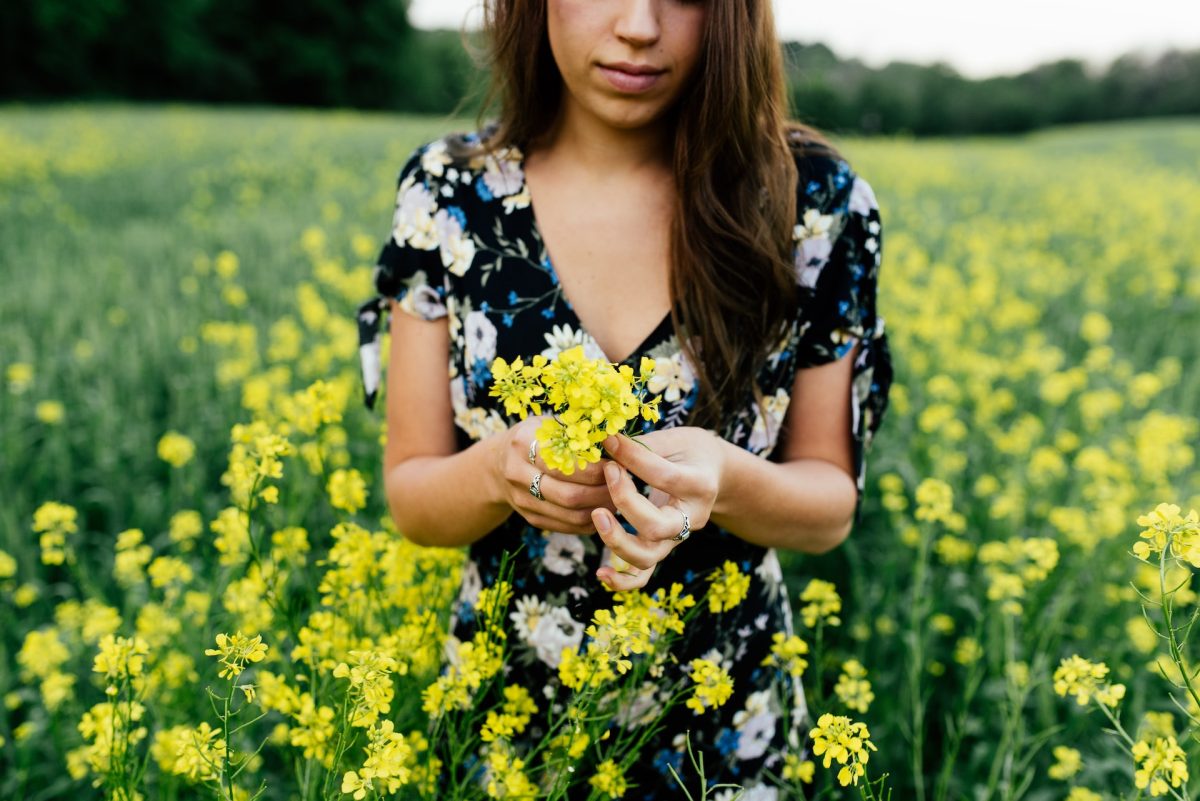 woman standing in a field of yellow flwoers