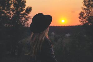 woman wearing black hat at sunset