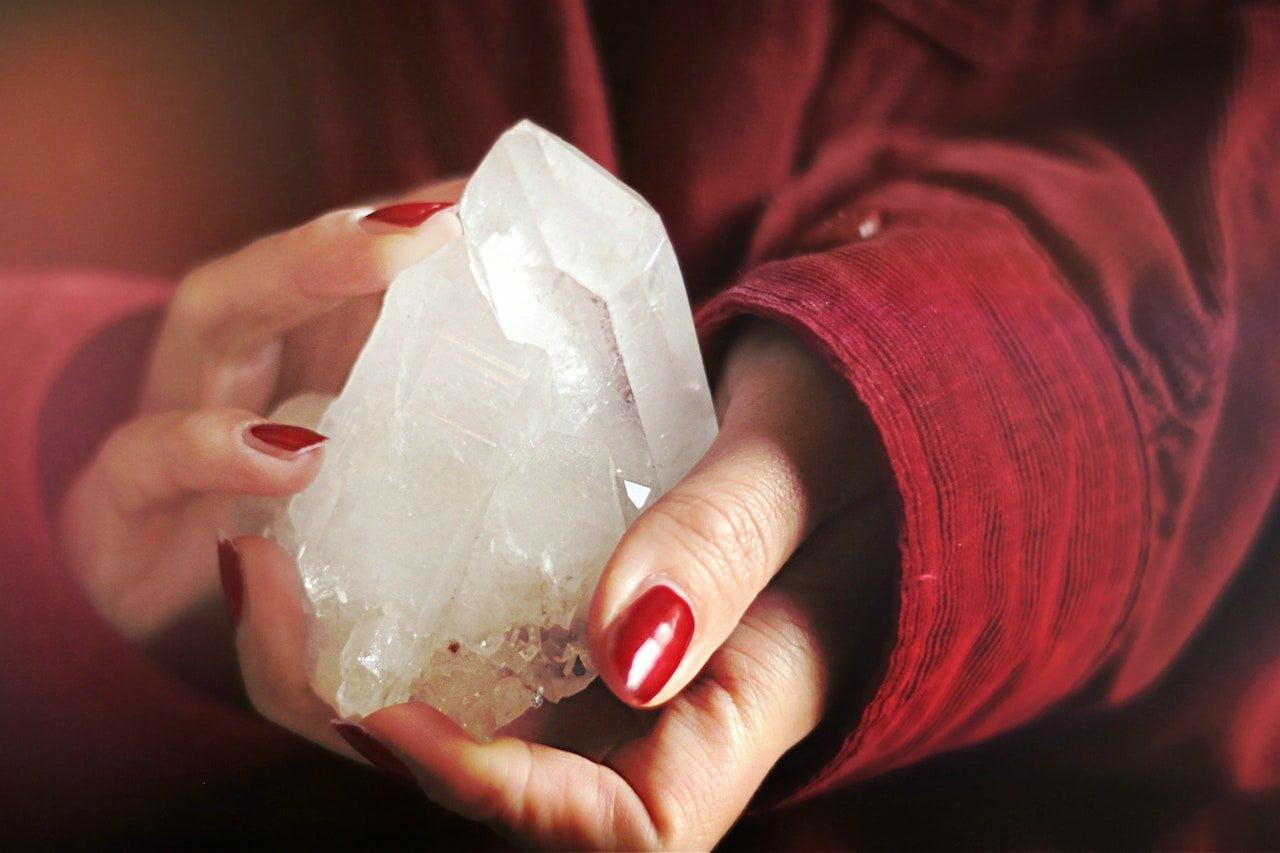 woman's hands holding quartz crystal
