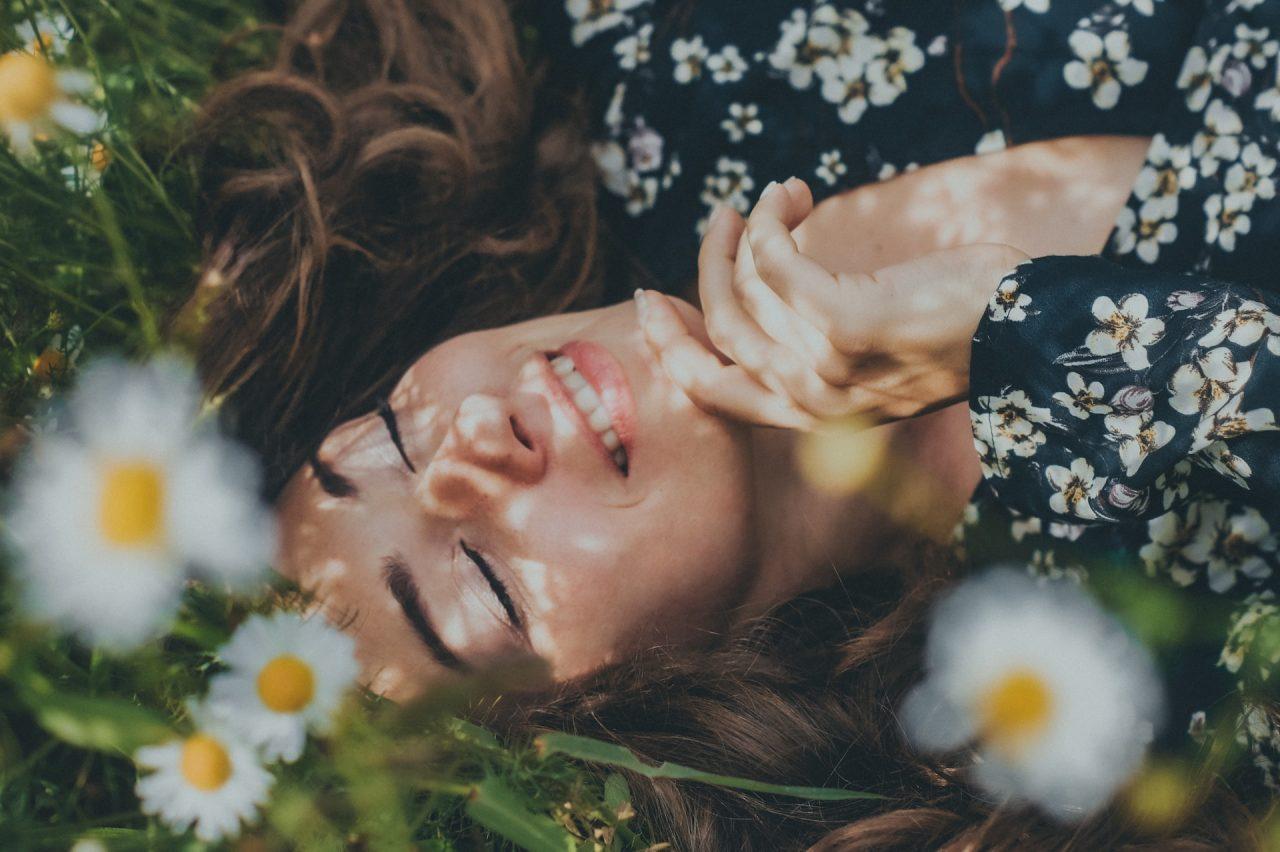 woman in floral dress laying in the grass