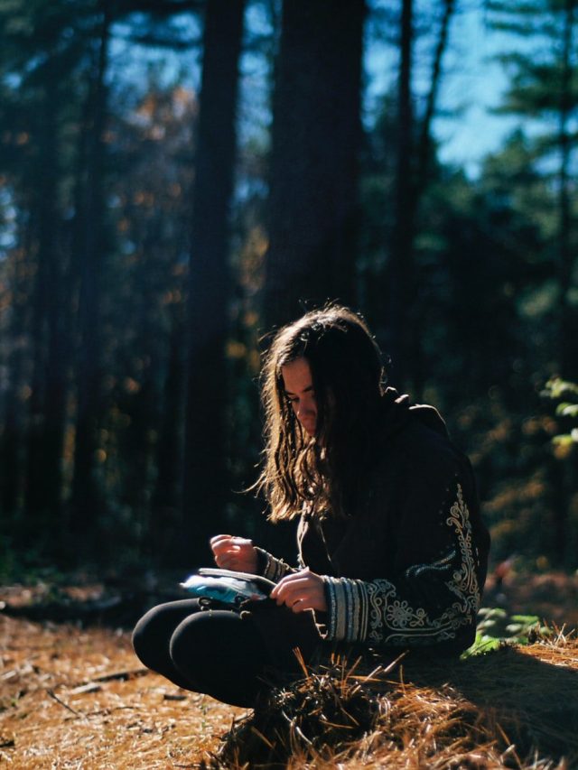 woman journaling in the woods