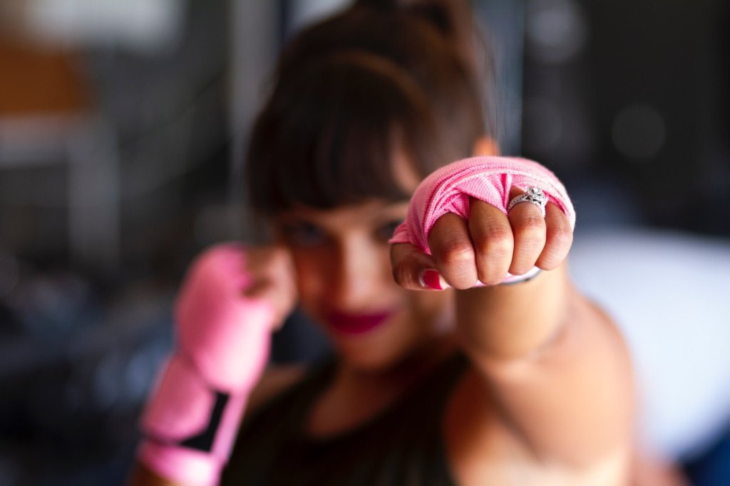 woman in pink boxing gloves making a fist