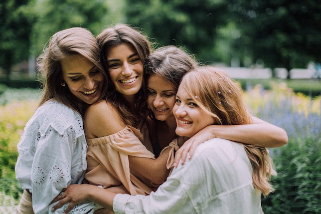 4 smiling women hugging