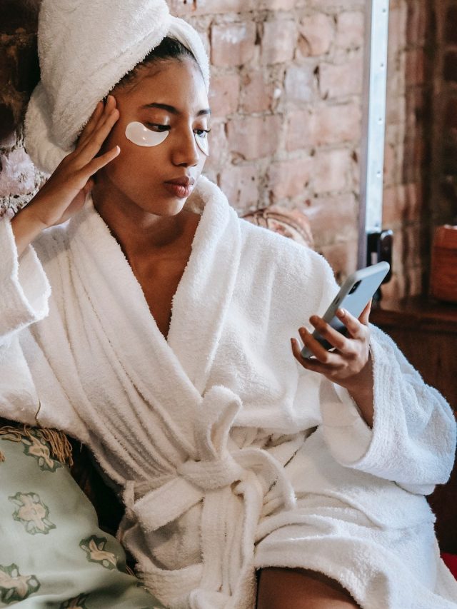 woman in white robe looking at phone