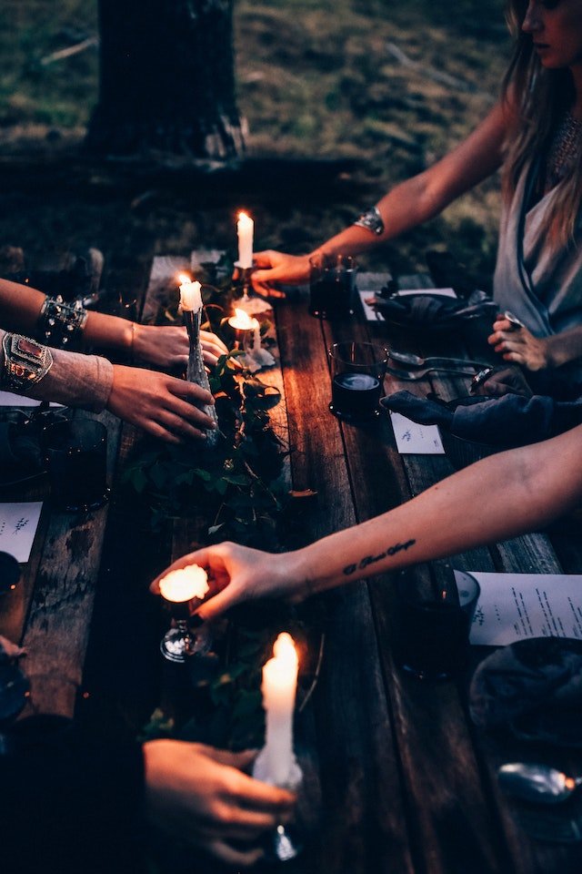 women sitting at a table with papers and candles
