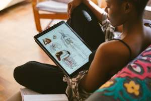 woman studying anatomy on tablet