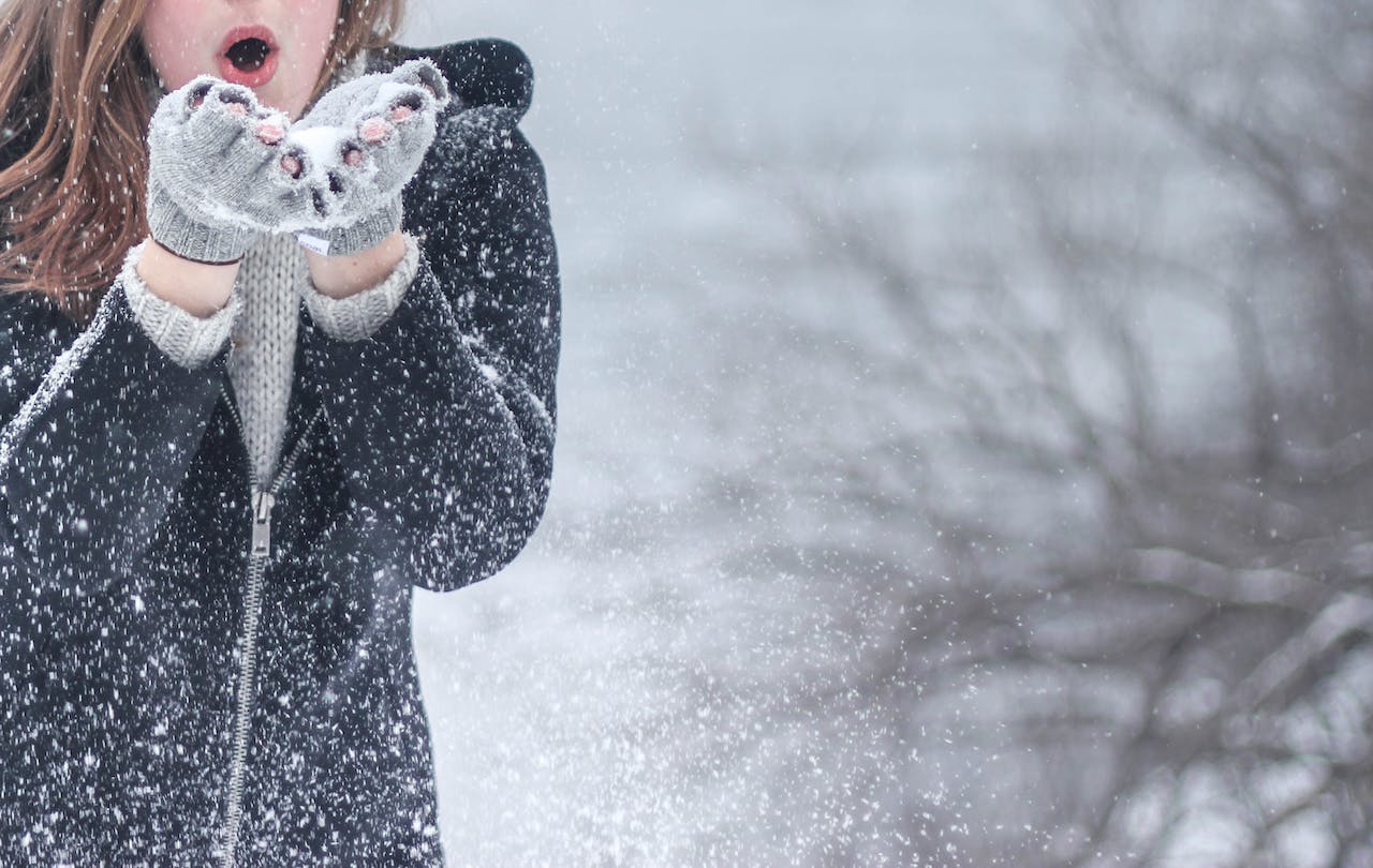 woman blowing a handful of snow