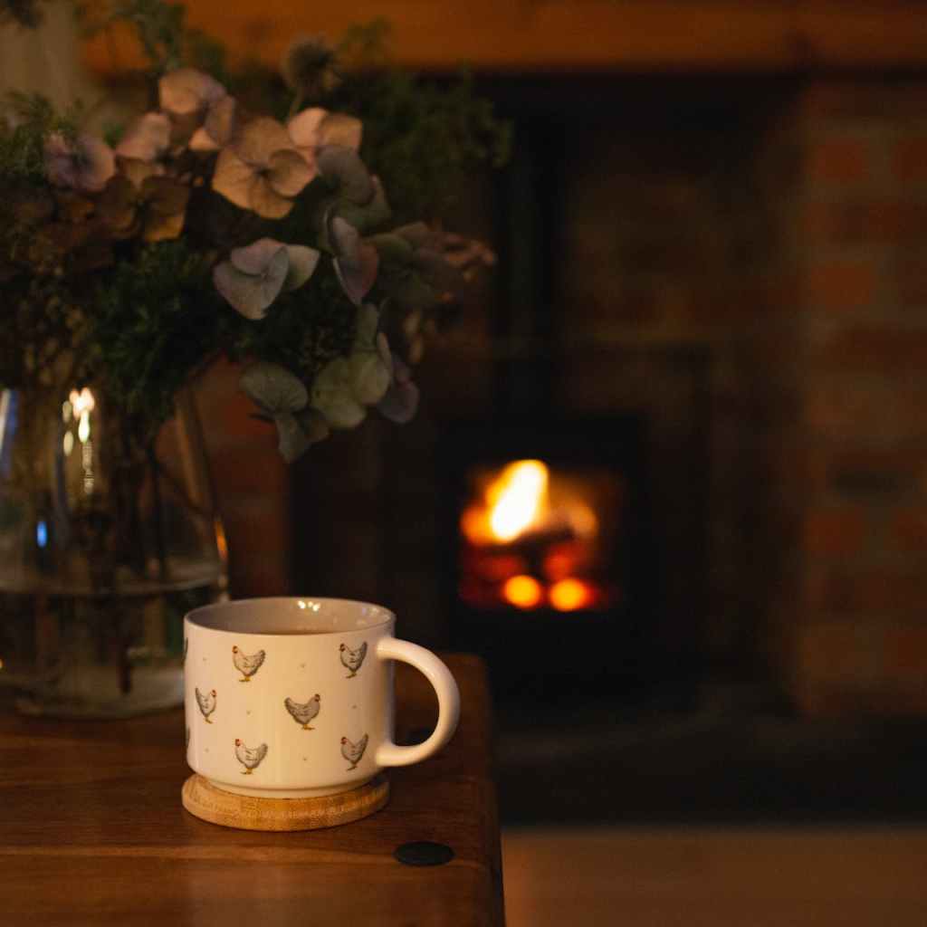teacup on table in front of a fireplace