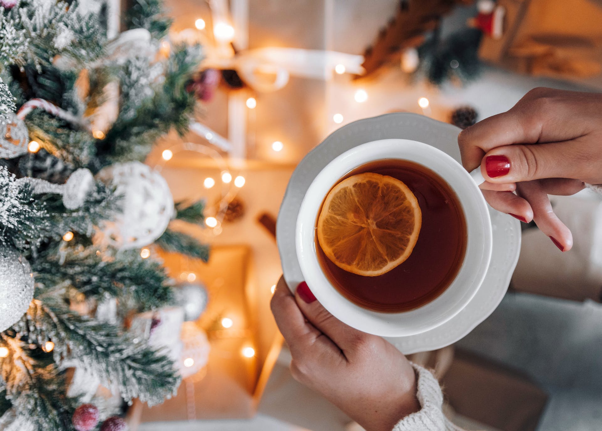 women holding teacup in front of christmas tree