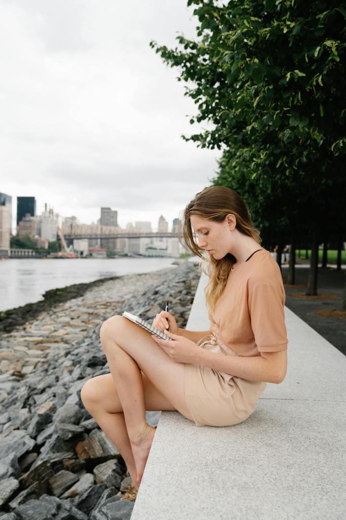 woman journaling in notebook outdoors