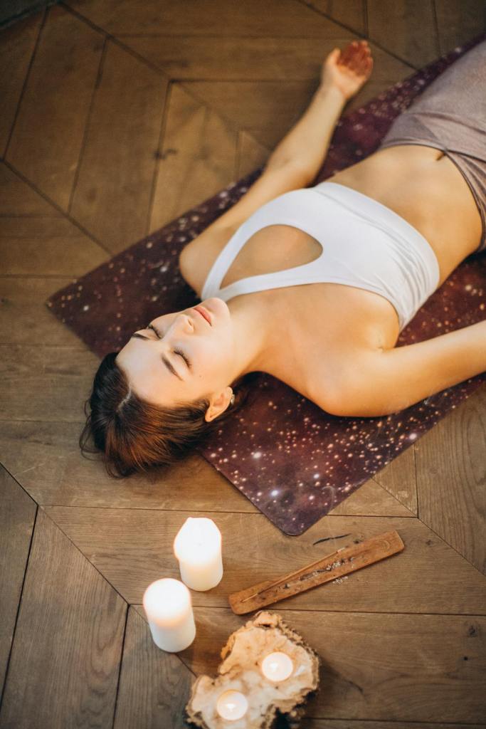 woman in savasana pose on yoga mat