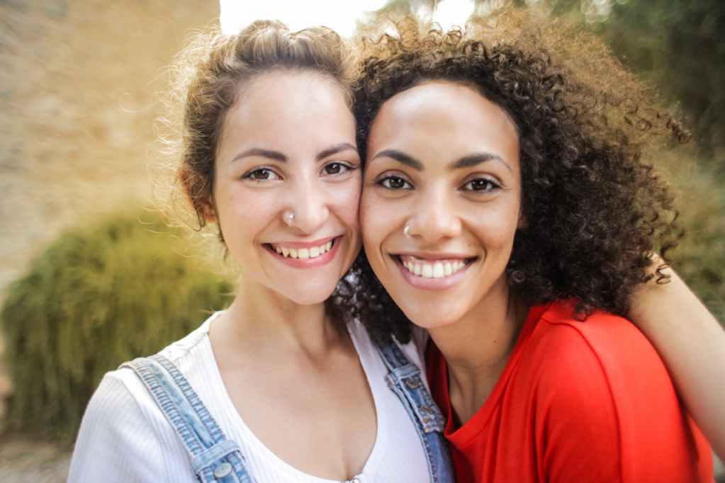 two smiling women standing side-by-side