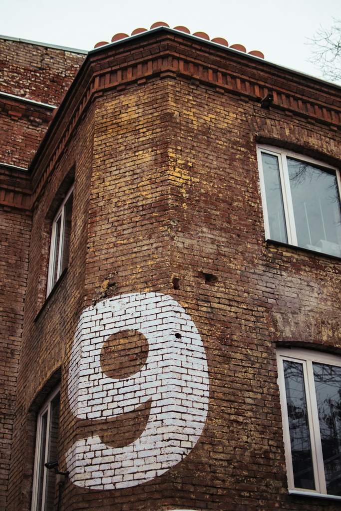 number 9 painted on brick building